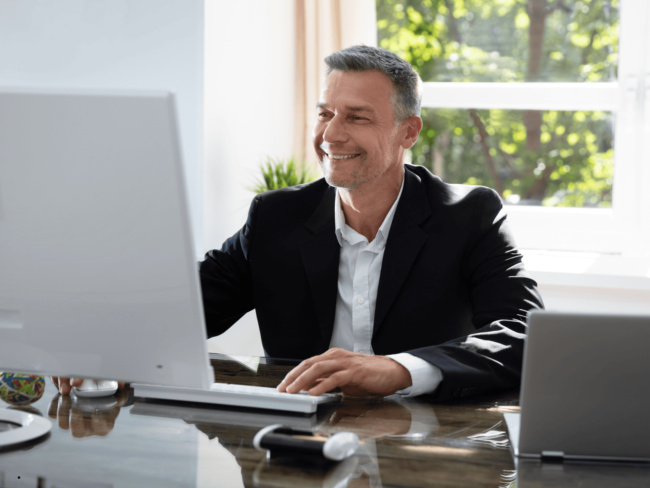 Ein Steuerberater am Schreibtisch arbeitet am Computer.