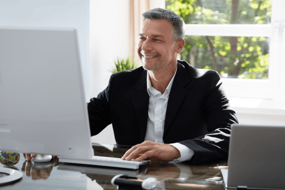 Ein Steuerberater am Schreibtisch arbeitet am Computer.