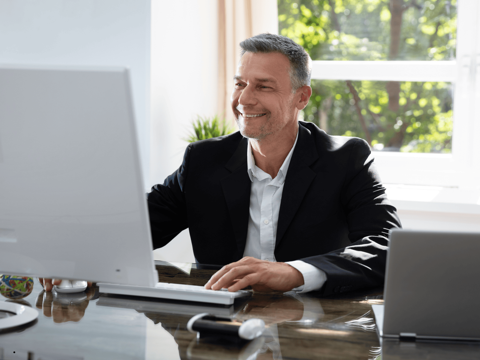 Google-Ranking verbessern: SEO für Steuerberater Ein Steuerberater am Schreibtisch arbeitet am Computer.